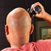 Man shaving his head with balder- back view